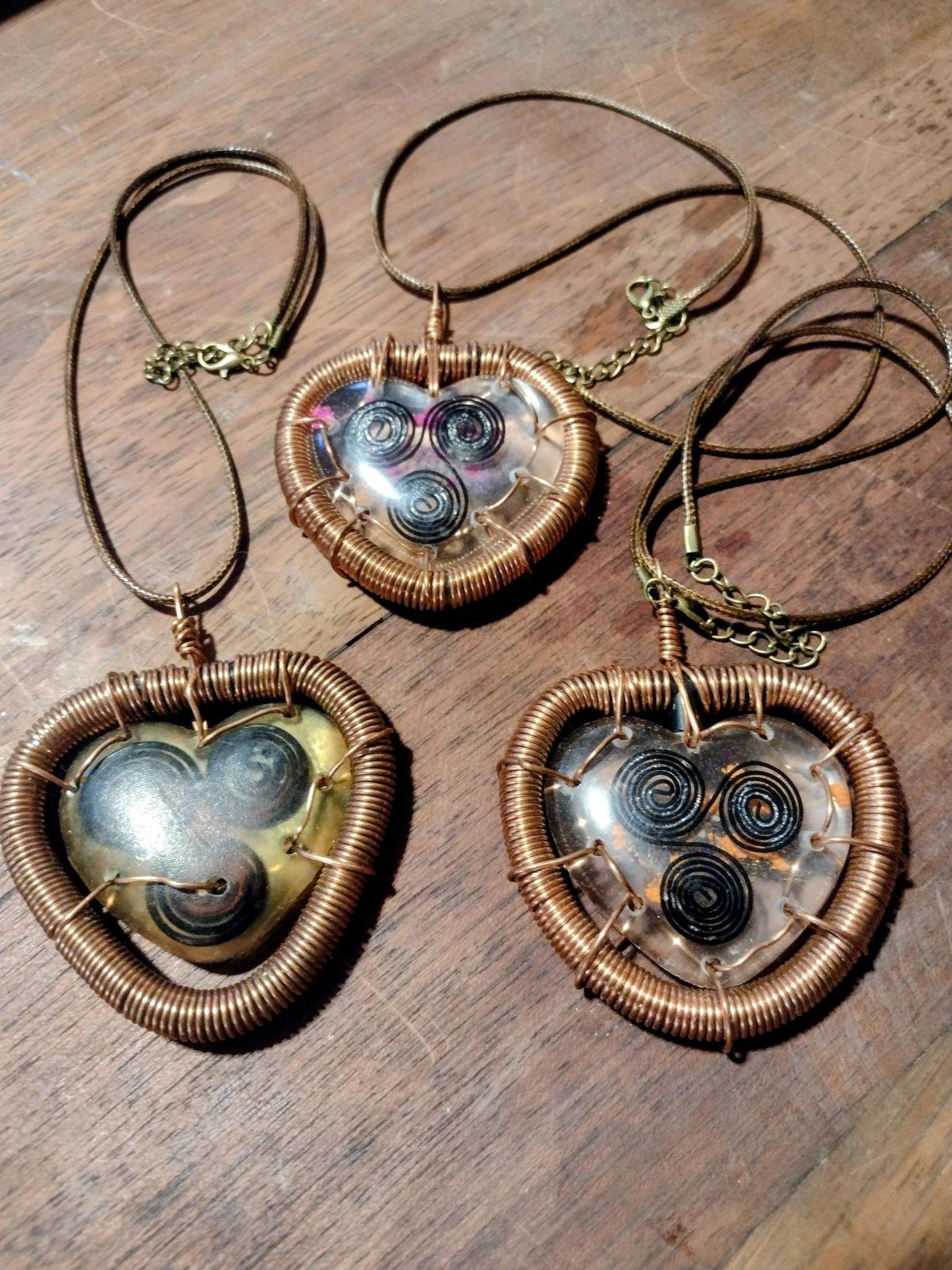Three Plasmanna Plasma Harmonizing Pendants — copper-wire triskelion hearts with GANS plasma water